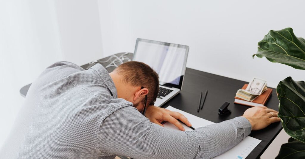 会社員がデスクで疲れ果てている様子を表現したイメージ